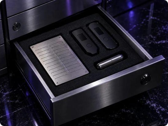 Steel vault drawer holding a steel seed phrase plate and two hardware wallets